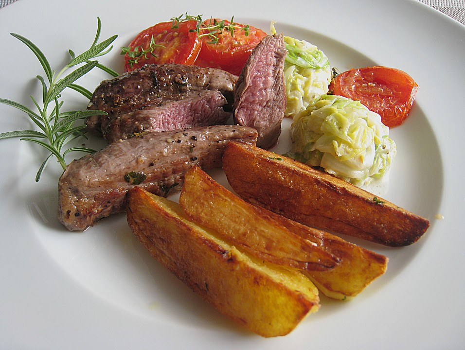 Lammfilet an Wirsing, geschmorten Tomatenscheiben und gebratenen Kartoffelvierteln