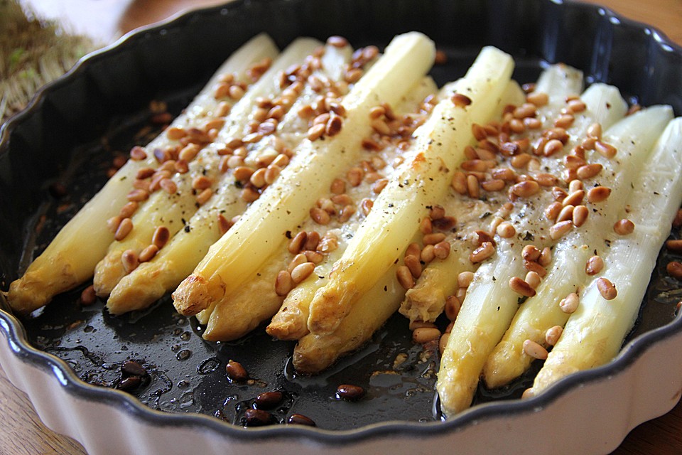 Weißer Spargel mit Pinienkernen und Parmesan überbacken