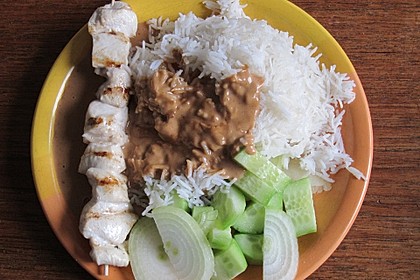 Saté Hühnerspieß in Erdnussbuttersauce mit Reis, Zwiebeln und Gurke (Bild)