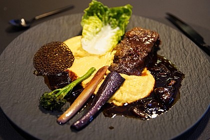 Ox Rib flambée auf Maisspiegel, mit Portwein-Schalotten und Rot, Grün und Lila (Bild)
