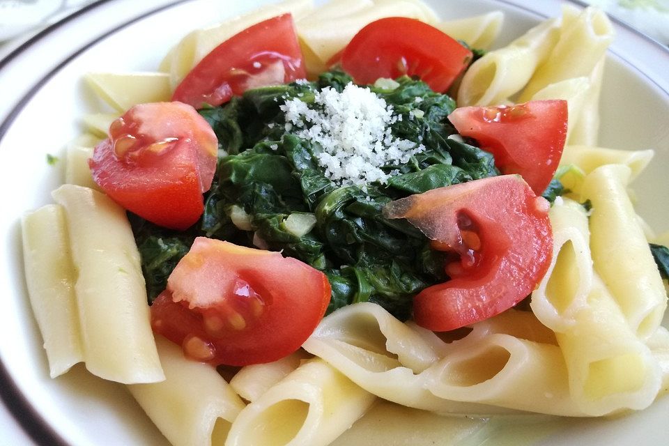 Gesundes Nudelgericht mit Blattspinat und Tomaten