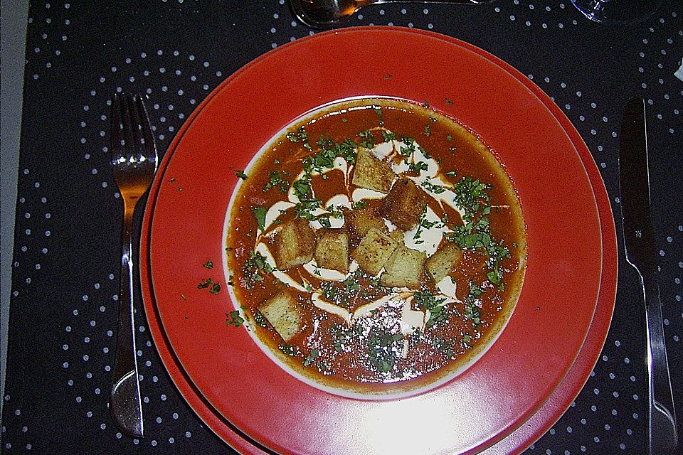 Tomatensuppe verziert mit Sahne, Balsamico und Croutons