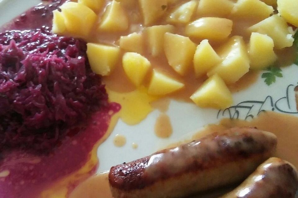 Frische Bratwurst in einer Apfel-Malzbier-Sauce mit Kartoffeln und Rotkohl