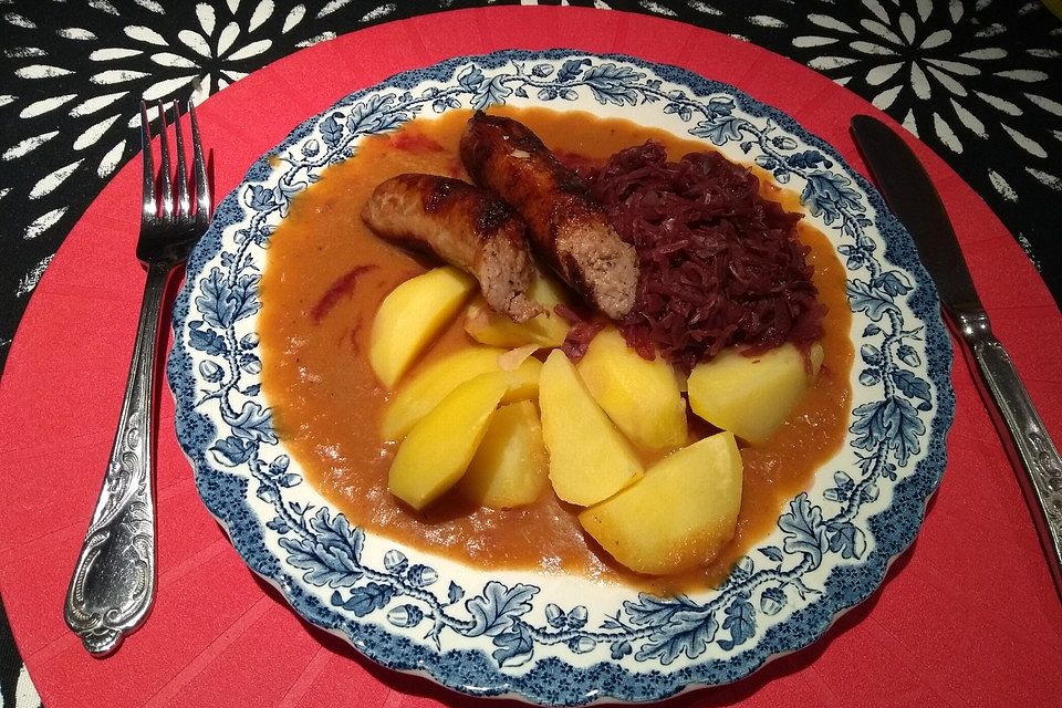 Frische Bratwurst in einer Apfel-Malzbier-Sauce mit Kartoffeln und Rotkohl