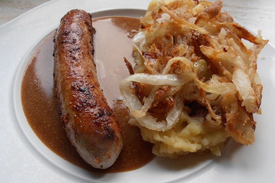 Frische Bratwurst in einer Apfel-Malzbier-Sauce mit Kartoffeln und Rotkohl