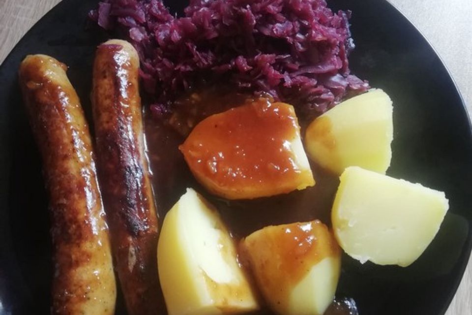 Frische Bratwurst in einer Apfel-Malzbier-Sauce mit Kartoffeln und Rotkohl