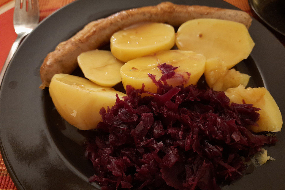 Frische Bratwurst in einer Apfel-Malzbier-Sauce mit Kartoffeln und Rotkohl