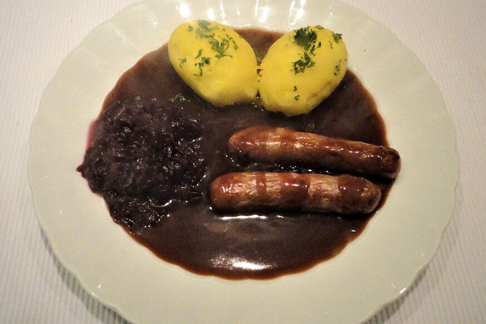 Frische Bratwurst in einer Apfel-Malzbier-Sauce mit Kartoffeln und Rotkohl