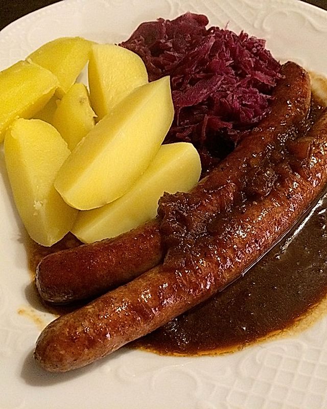 Frische Bratwurst in einer Apfel-Malzbier-Sauce mit Kartoffeln und Rotkohl
