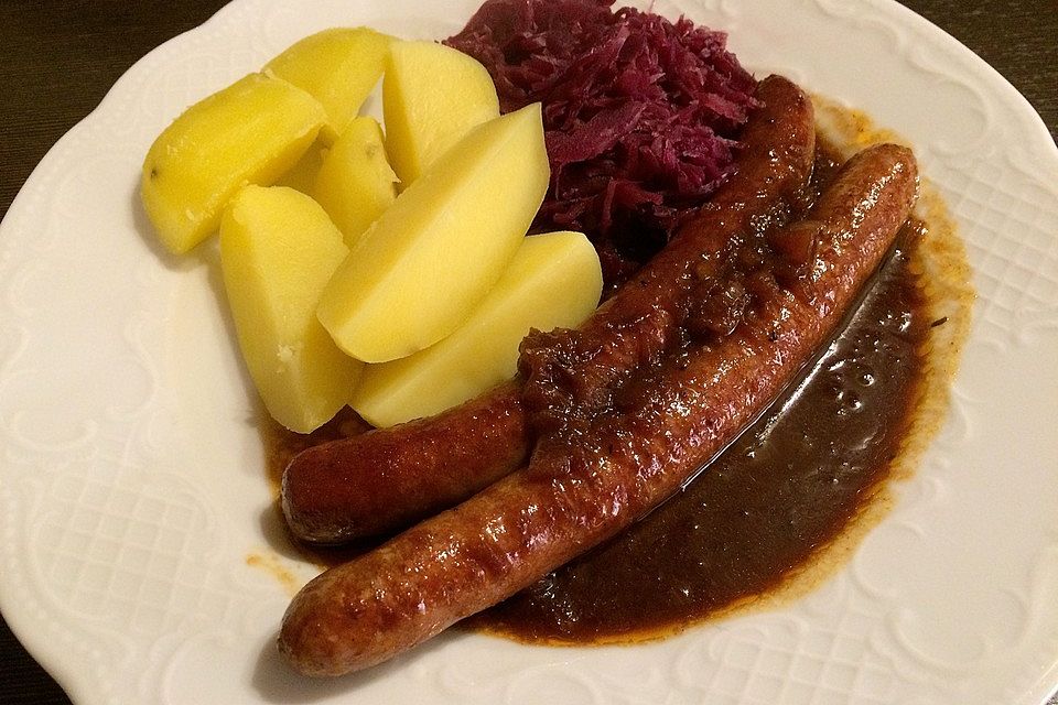 Frische Bratwurst in einer Apfel-Malzbier-Sauce mit Kartoffeln und Rotkohl