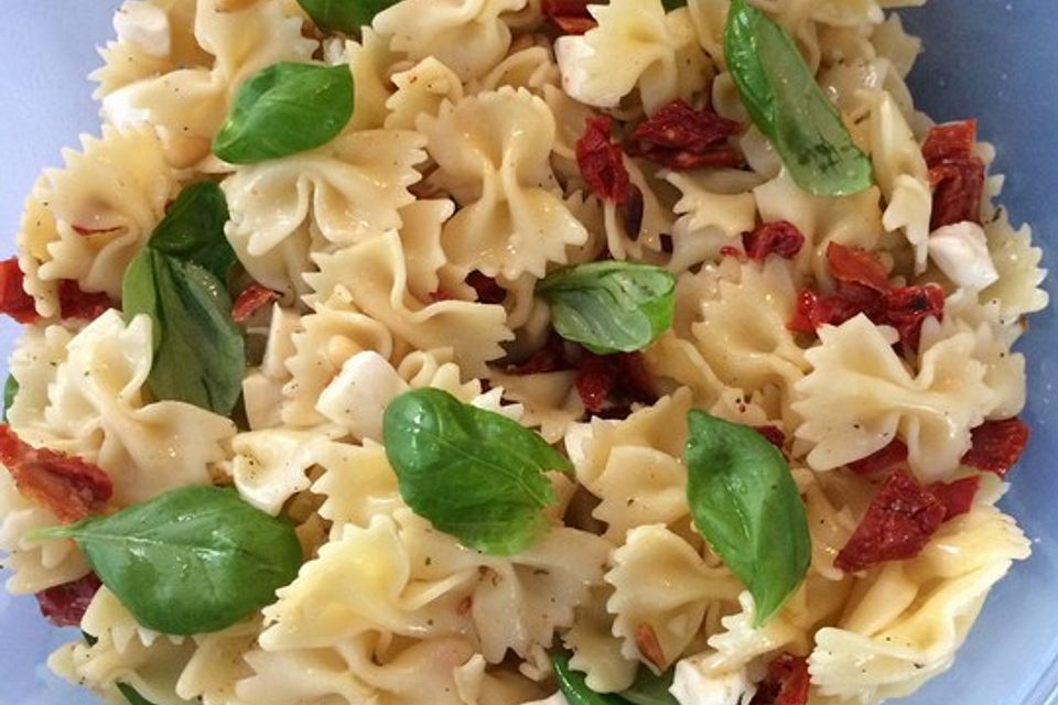 Nudelsalat mit getrockneten Tomaten, Pinienkernen, Schafskäse und Basilikum