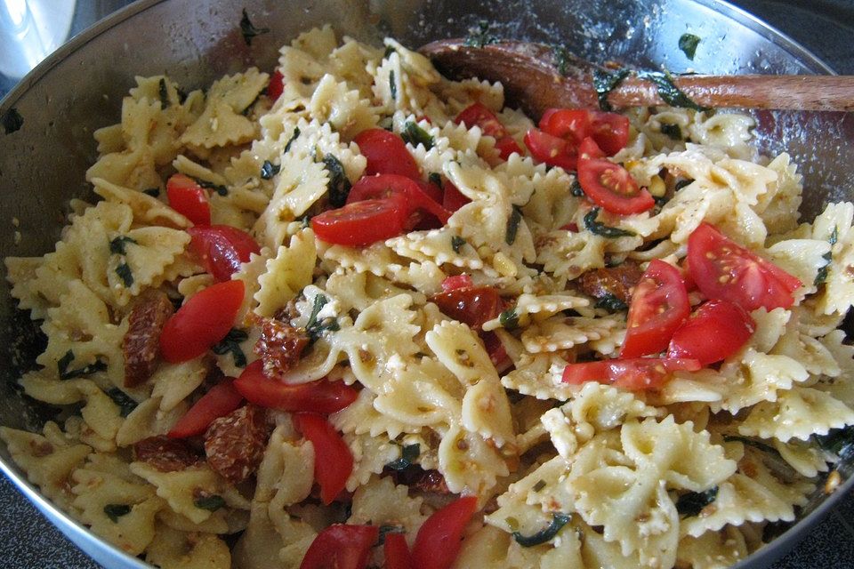 Nudelsalat mit getrockneten Tomaten, Pinienkernen, Schafskäse und Basilikum