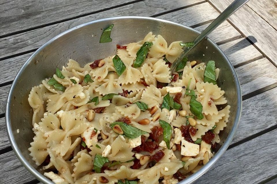 Nudelsalat mit getrockneten Tomaten, Pinienkernen, Schafskäse und Basilikum