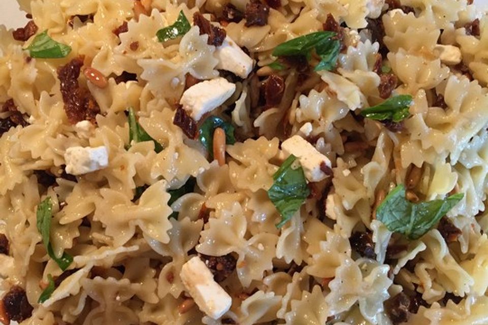 Nudelsalat mit getrockneten Tomaten, Pinienkernen, Schafskäse und Basilikum