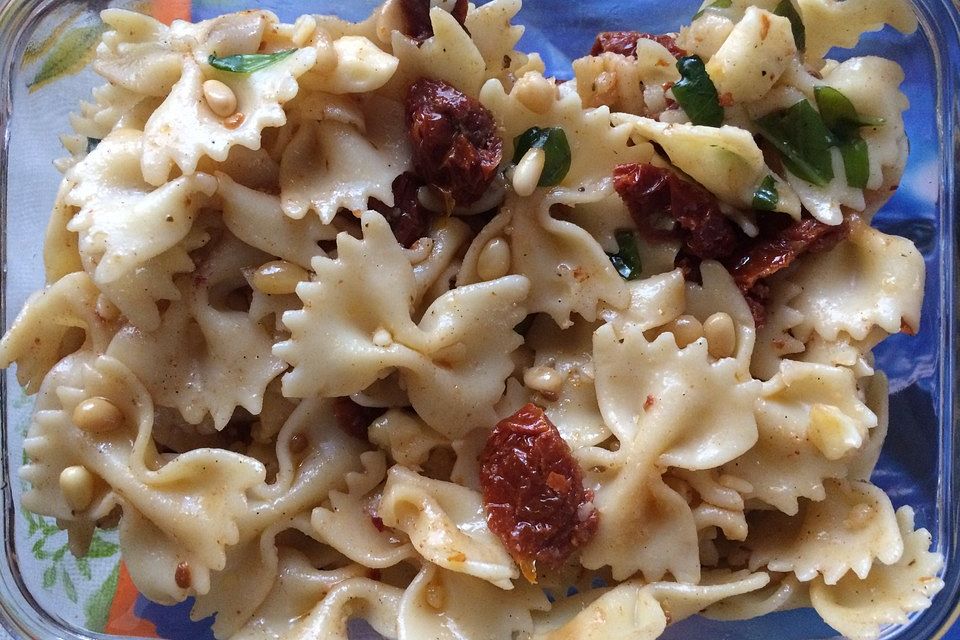 Nudelsalat mit getrockneten Tomaten, Pinienkernen, Schafskäse und Basilikum