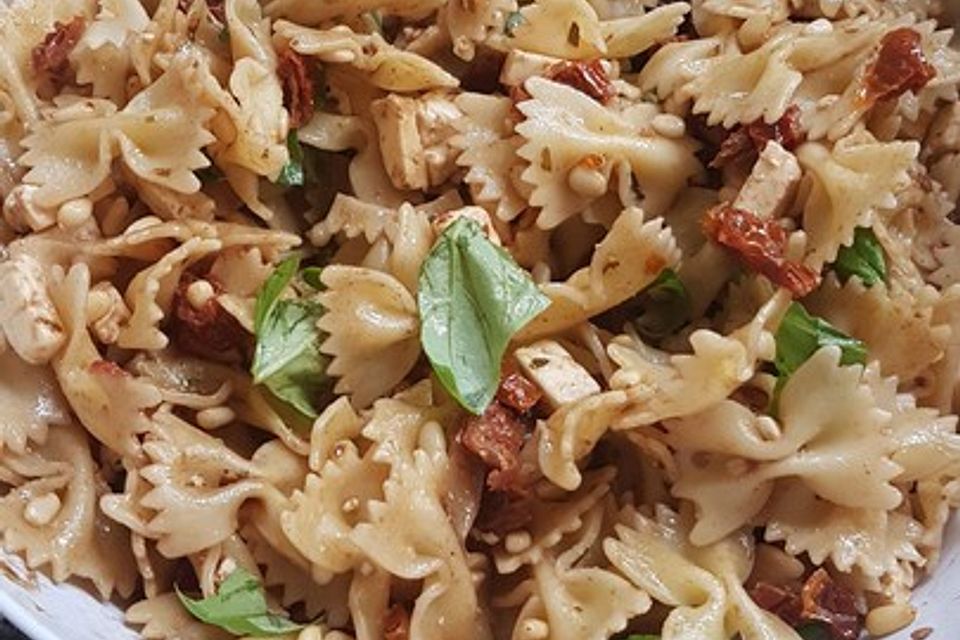 Nudelsalat mit getrockneten Tomaten, Pinienkernen, Schafskäse und Basilikum