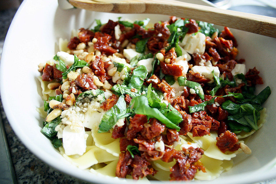 Nudelsalat mit getrockneten Tomaten, Pinienkernen, Schafskäse und Basilikum