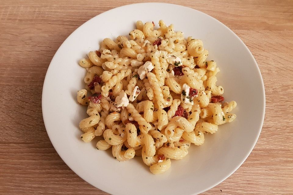 Nudelsalat mit getrockneten Tomaten, Pinienkernen, Schafskäse und Basilikum