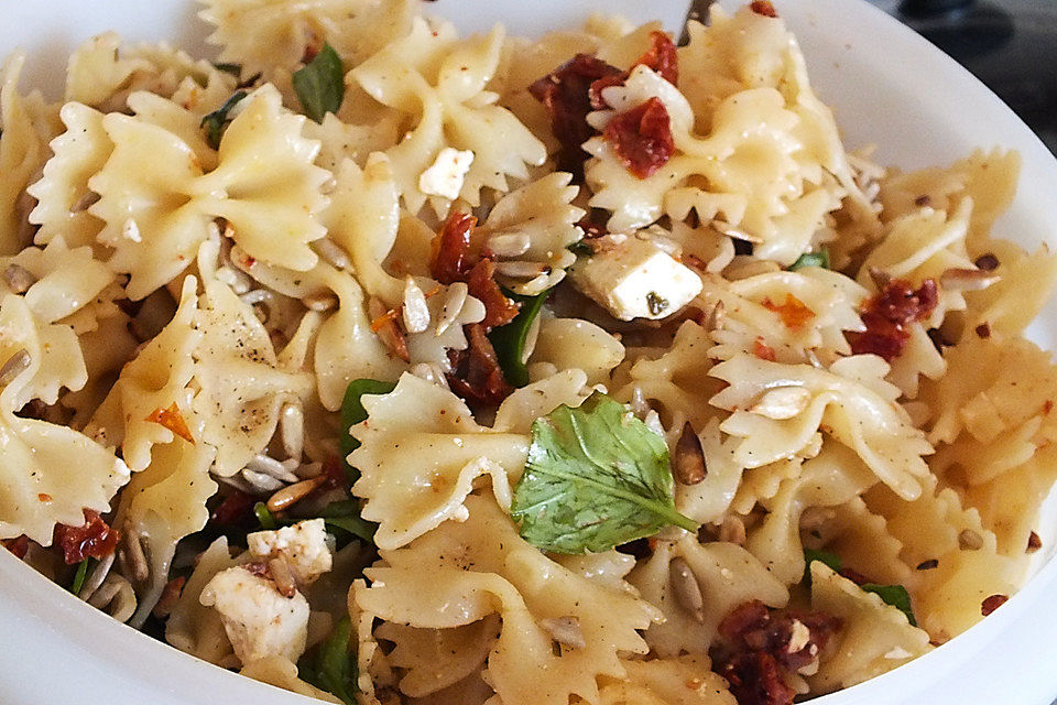 Nudelsalat mit getrockneten Tomaten, Pinienkernen, Schafskäse und Basilikum