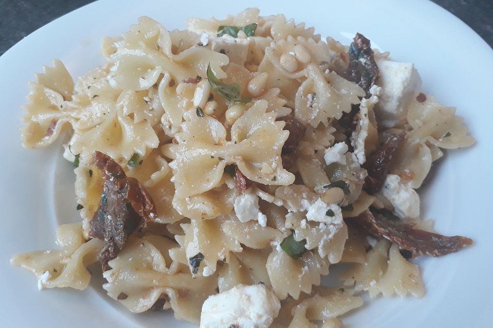 Nudelsalat mit getrockneten Tomaten, Pinienkernen, Schafskäse und Basilikum