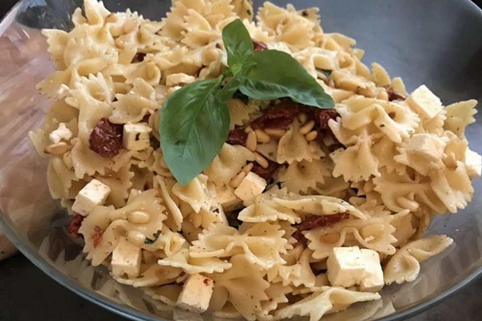 Nudelsalat mit getrockneten Tomaten, Pinienkernen, Schafskäse und Basilikum