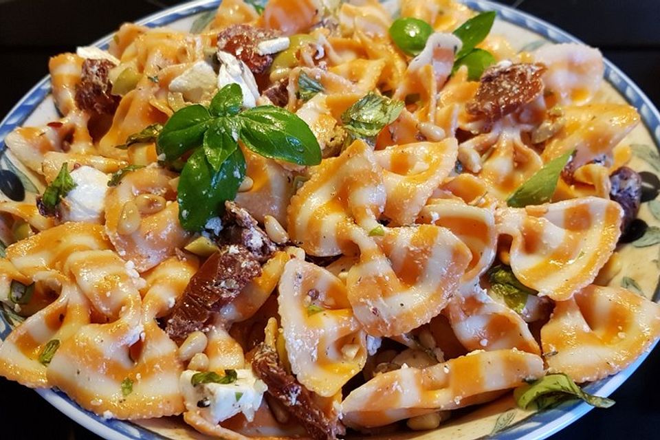 Nudelsalat mit getrockneten Tomaten, Pinienkernen, Schafskäse und Basilikum