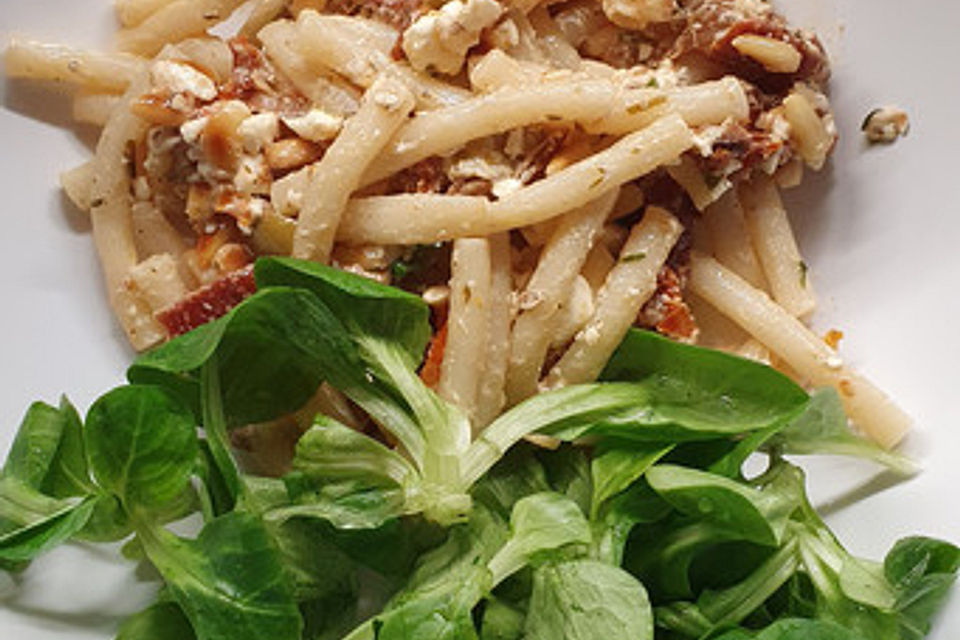 Nudelsalat mit getrockneten Tomaten, Pinienkernen, Schafskäse und Basilikum