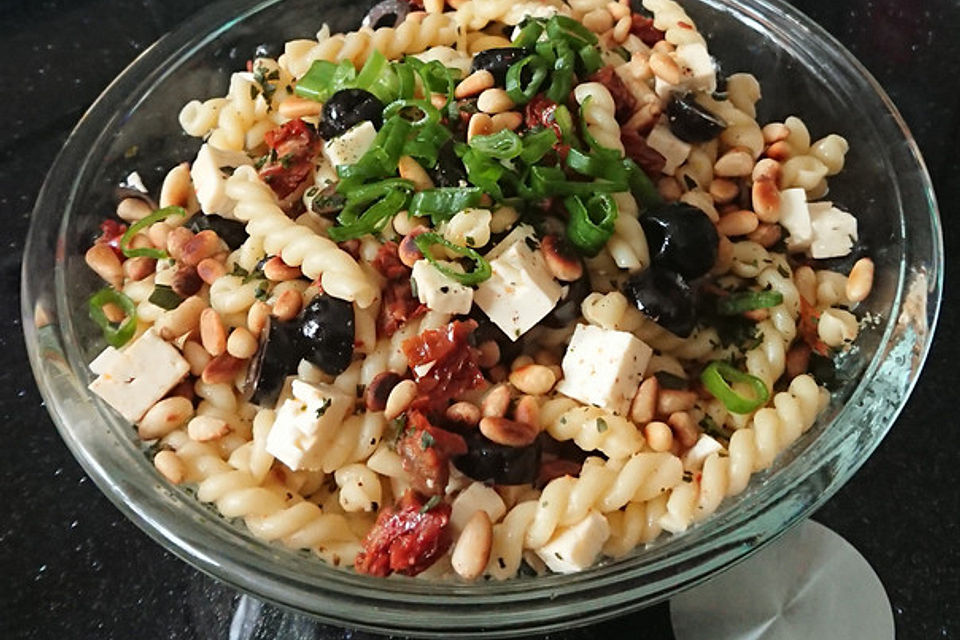 Nudelsalat mit getrockneten Tomaten, Pinienkernen, Schafskäse und Basilikum