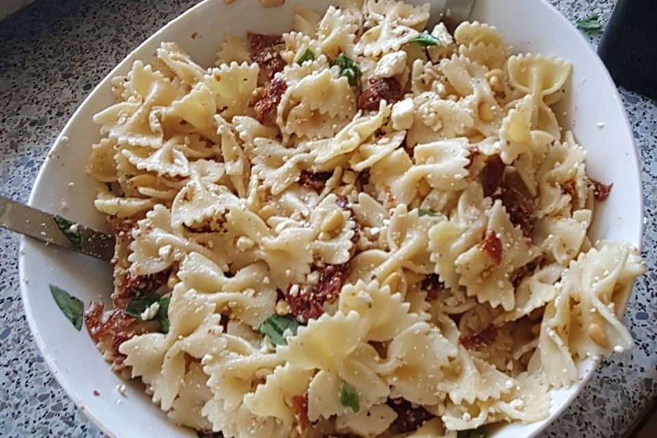 Nudelsalat mit getrockneten Tomaten, Pinienkernen, Schafskäse und Basilikum