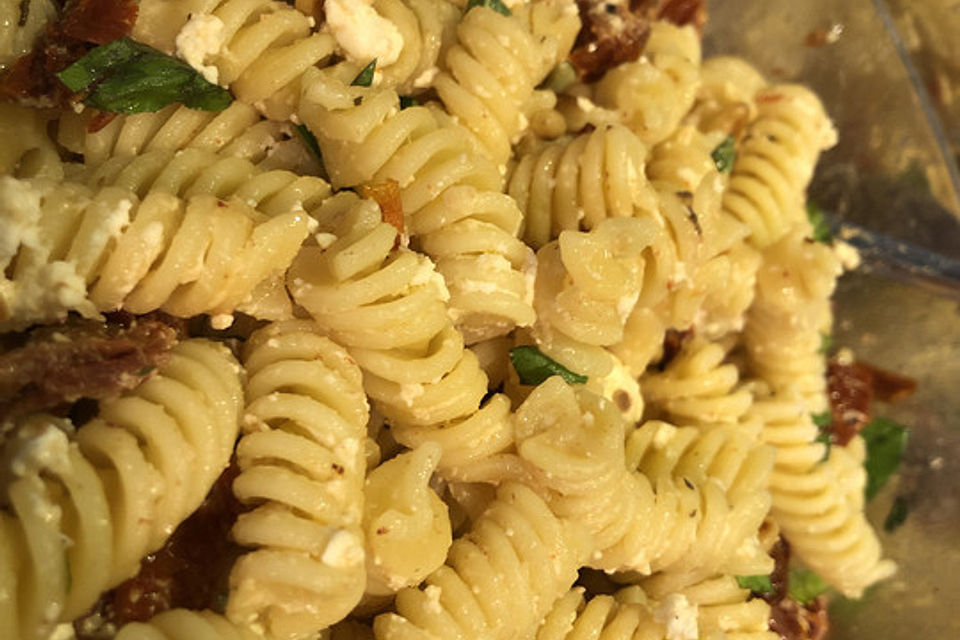 Nudelsalat mit getrockneten Tomaten, Pinienkernen, Schafskäse und Basilikum