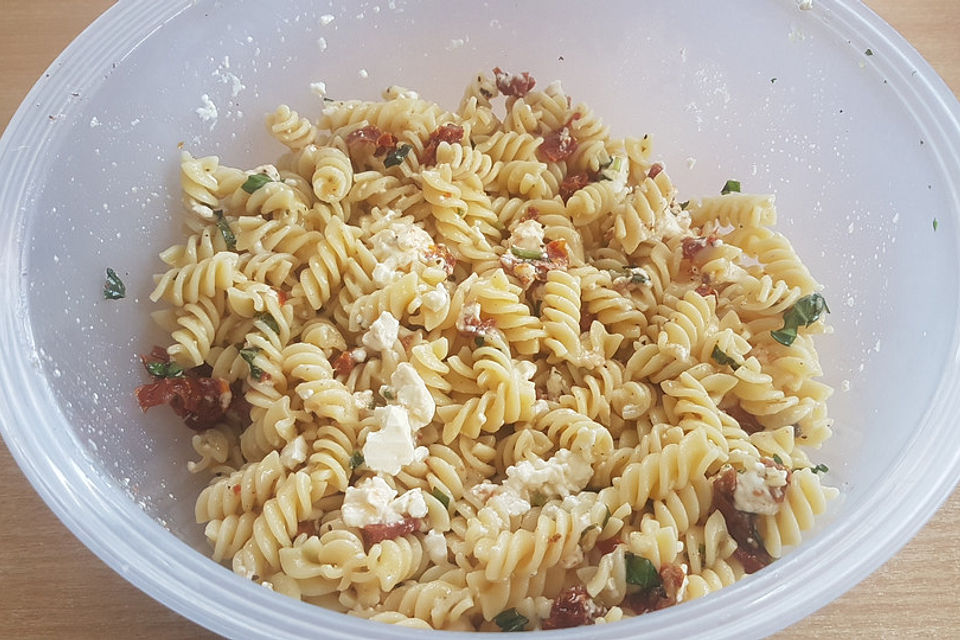 Nudelsalat mit getrockneten Tomaten, Pinienkernen, Schafskäse und Basilikum