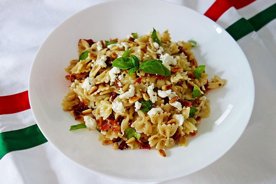 Nudelsalat mit getrockneten Tomaten, Pinienkernen, Schafskäse und Basilikum