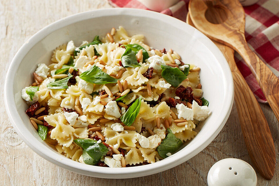 Nudelsalat mit getrockneten Tomaten, Pinienkernen, Schafskäse und Basilikum