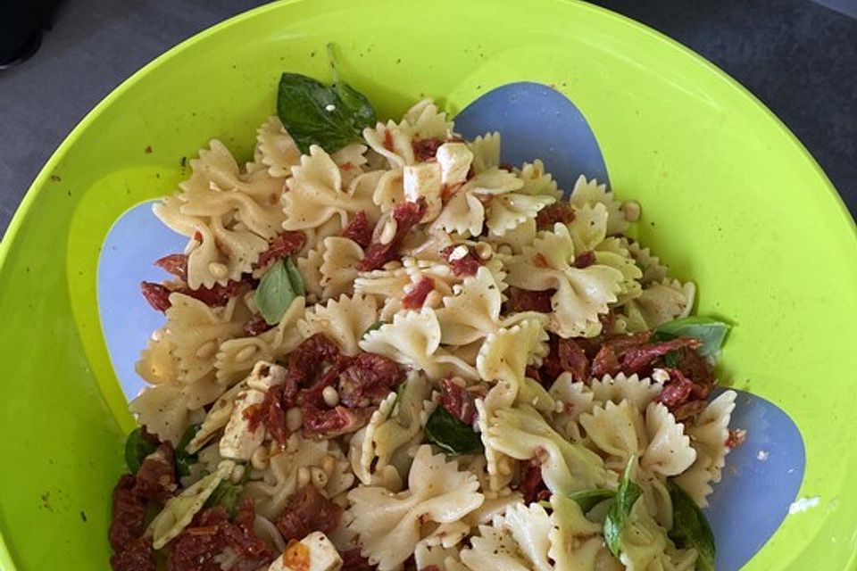 Nudelsalat mit getrockneten Tomaten, Pinienkernen, Schafskäse und Basilikum