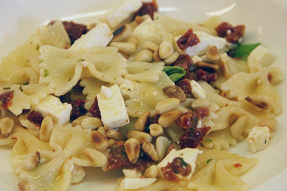 Nudelsalat mit getrockneten Tomaten, Pinienkernen, Schafskäse und Basilikum