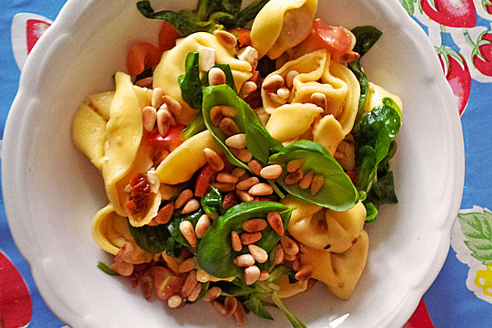 Nudelsalat mit getrockneten Tomaten, Pinienkernen, Schafskäse und Basilikum