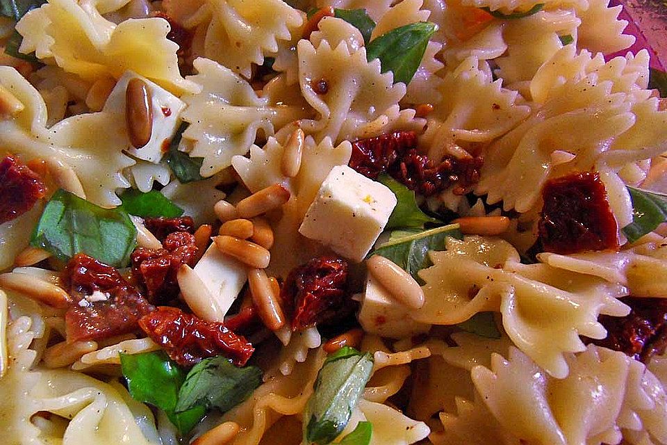 Nudelsalat mit getrockneten Tomaten, Pinienkernen, Schafskäse und Basilikum