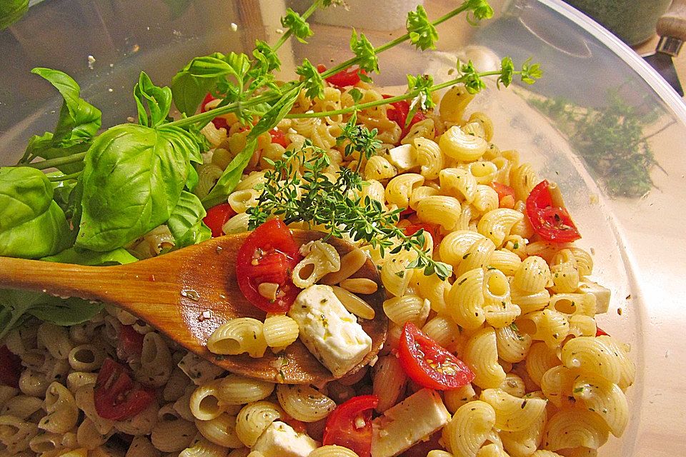 Nudelsalat mit getrockneten Tomaten, Pinienkernen, Schafskäse und Basilikum