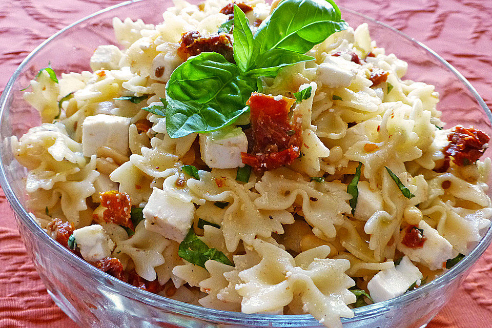 Nudelsalat mit getrockneten Tomaten, Pinienkernen, Schafskäse und Basilikum