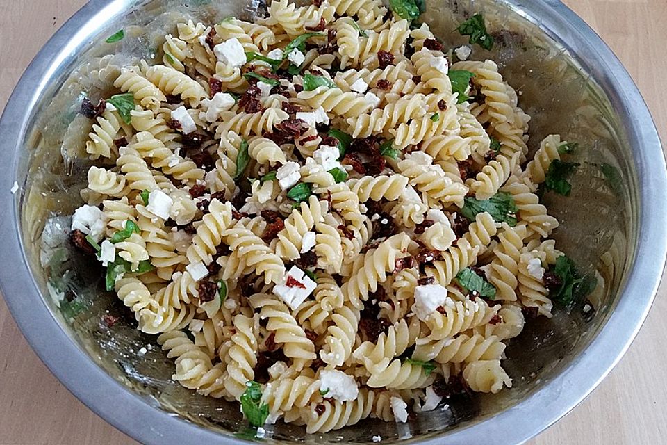 Nudelsalat mit getrockneten Tomaten, Pinienkernen, Schafskäse und Basilikum