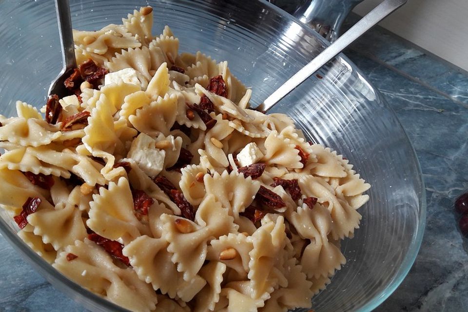 Nudelsalat mit getrockneten Tomaten, Pinienkernen, Schafskäse und Basilikum