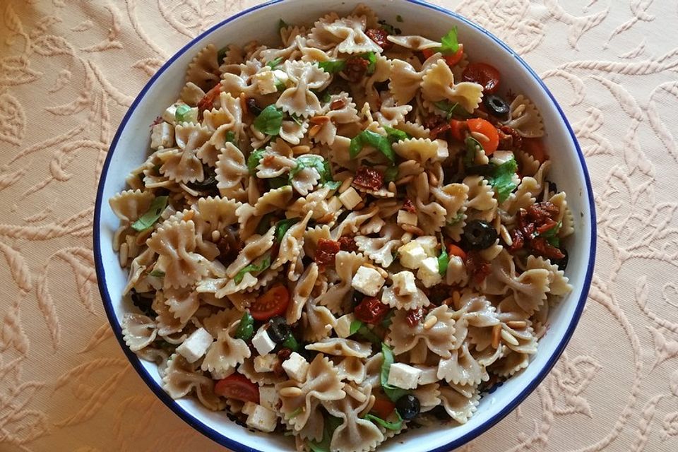 Nudelsalat mit getrockneten Tomaten, Pinienkernen, Schafskäse und Basilikum