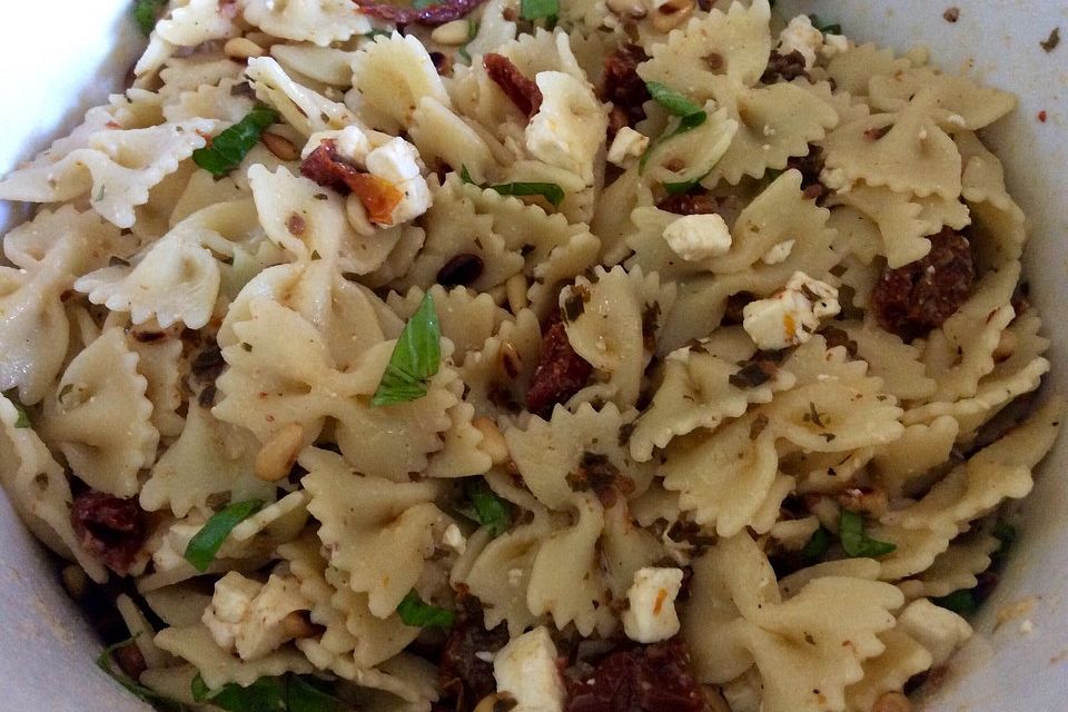 Nudelsalat mit getrockneten Tomaten, Pinienkernen, Schafskäse und Basilikum