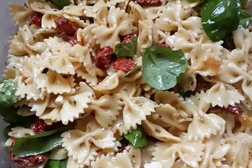 Nudelsalat mit getrockneten Tomaten, Pinienkernen, Schafskäse und Basilikum