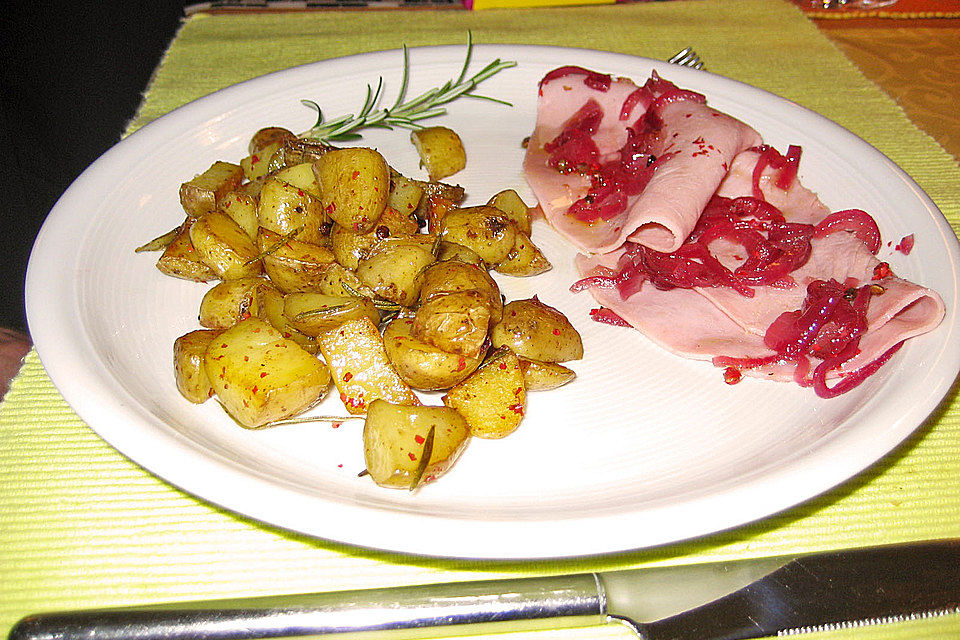 Gekochter Schinken, angemacht mit roten Zwiebeln und rosa Beeren