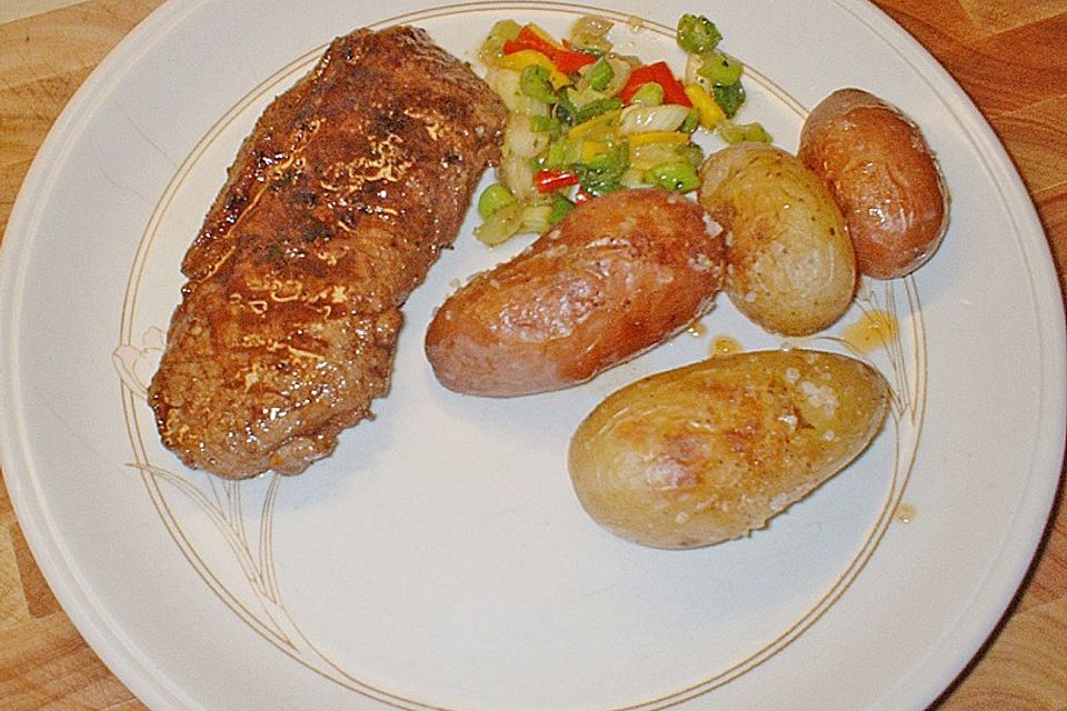 Rumpsteak mit bunten Peperoni und Frühlingszwiebeln an zweifarbigen Backofenkartoffeln