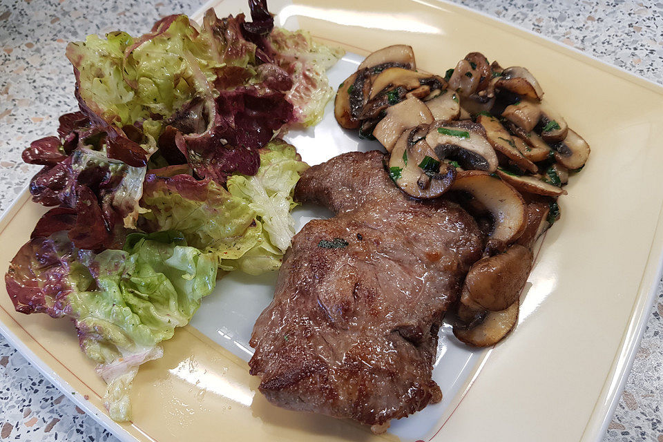 Filetsteak auf Salat mit gebratenen Pilzen