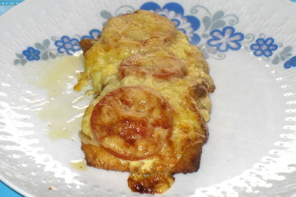 Überbackenes Schnitzel mit Schmelzkäse und Tomaten