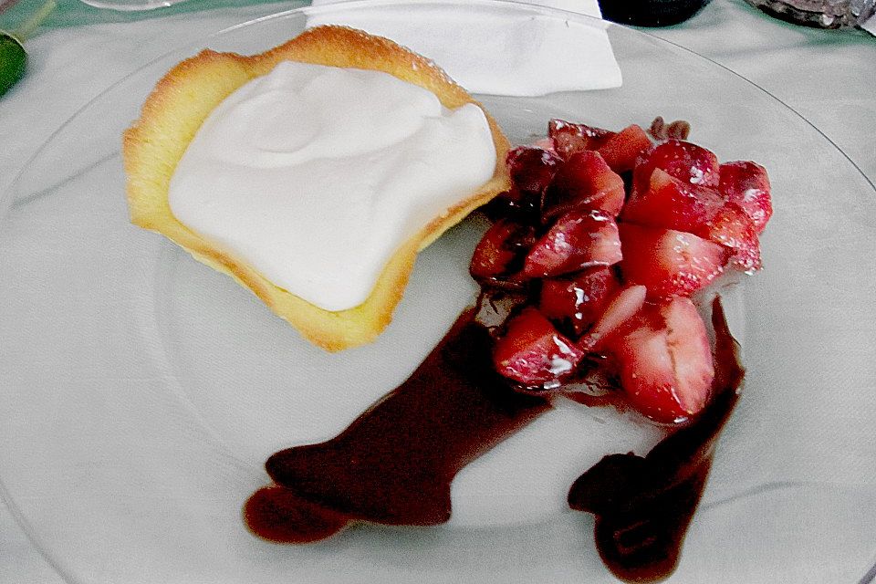 Weiße Schokoladenmousse in Orangenhippen an frischen Erdbeeren