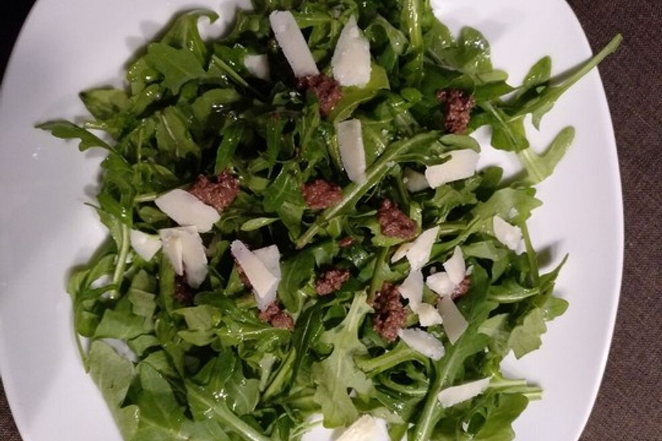 Rucola auf Tapenade mit Grana Padano